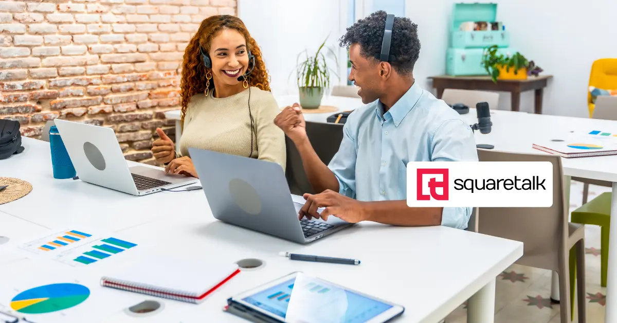 Two happy call center voice analytics agents working in the office